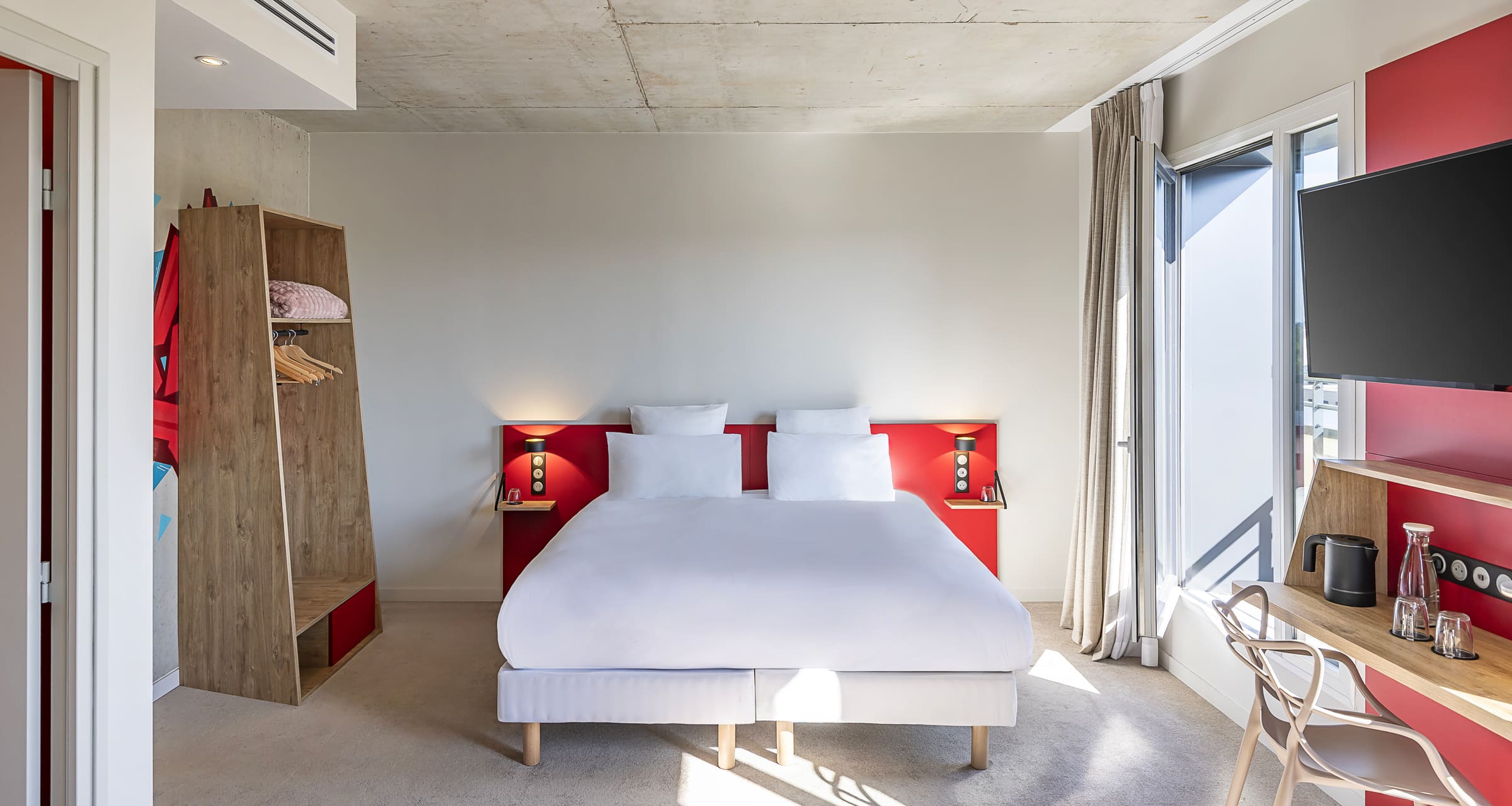 Chambre Executive · tête de lit rouge, dressing bois, accès balcon